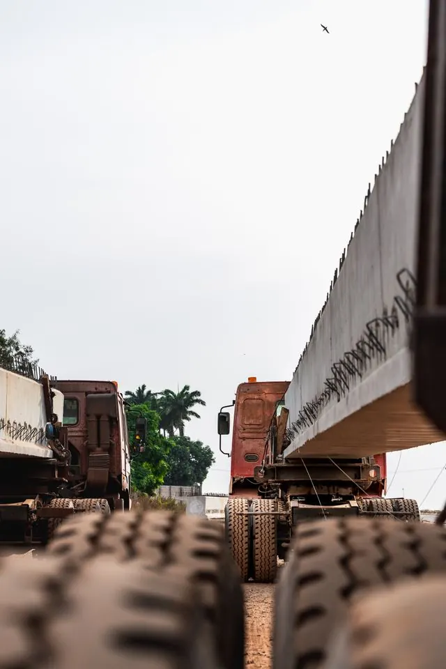 Container trucks queuing beneath an overpass